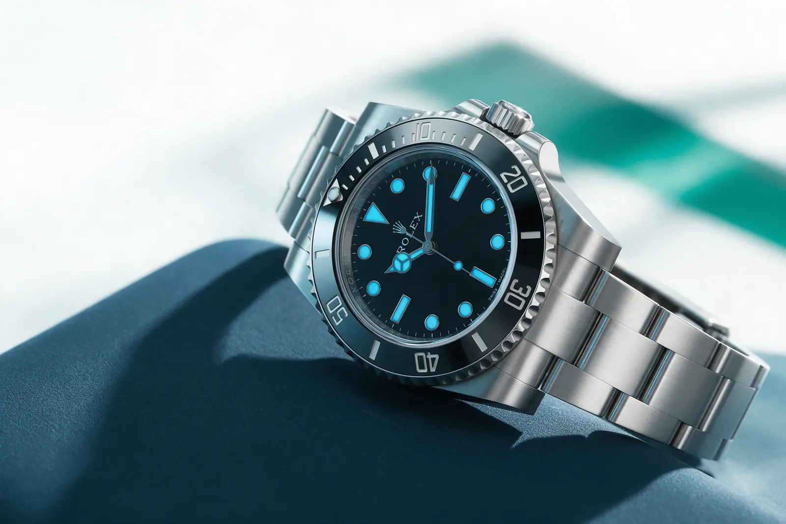A steel Rolex diver’s watch resting on a midnight-blue cloth