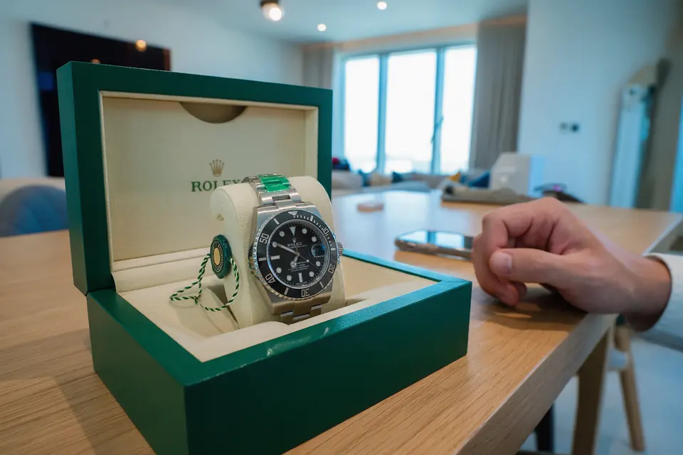 A brand-new Rolex Submariner Date with its protective stickers on, in its open green box
